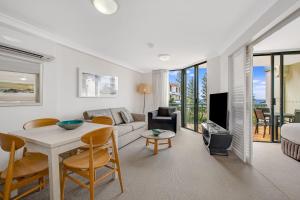 a living room with a couch and a table at Calypso Plaza Resort Unit 429 in Gold Coast