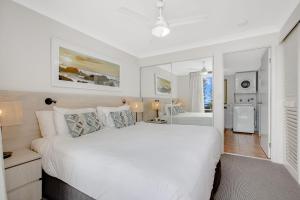una camera bianca con un grande letto e un bagno di Calypso Plaza Resort Unit 429 a Gold Coast