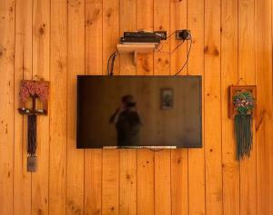 TV de pantalla plana colgada en una pared de madera en Cabaña en el bosque de las Trancas, en Las Trancas
