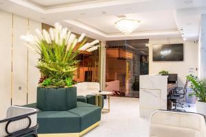 een woonkamer met een groene stoel en planten bij Ecstasy Hotel in Nha Trang