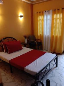 a bedroom with a bed with a red and white blanket at RedDoorz at Solid Rock Guest House Dipaculao Aurora in Dipaculao