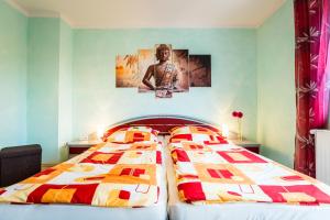 Dos camas en un dormitorio con dos posters en la pared en Ferienwohnung Köln Messenähe en Colonia