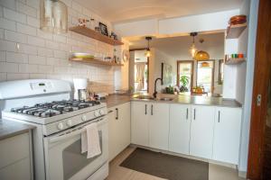 a white kitchen with a stove and a sink at Apartamento Brown Vinyl - Alamos in Cochabamba