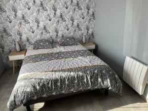 um quarto com uma cama com um cobertor preto e branco em Au lac du der em Voillecomte