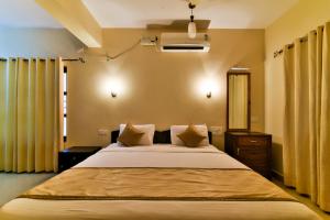 バガにあるBaga Fantacia Beach Innのベッドルーム1室(黄色のカーテン付きの大型ベッド1台付)