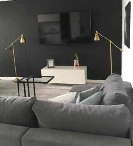 salon z szarą kanapą i stołem w obiekcie Apartament Miętowa Zebra w Olsztynie