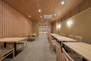 ein Esszimmer mit Holztischen und -stühlen in der Unterkunft Welina Hotel Shinsaibashi NAGOMI in Osaka