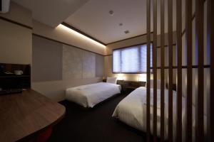 大阪市にあるWelina Hotel Shinsaibashi NAGOMIのベッド2台と窓が備わるホテルルームです。