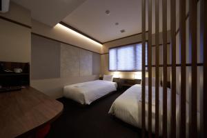 大阪市にあるWelina Hotel Shinsaibashi NAGOMIのベッドが2つと窓があるホテルの部屋
