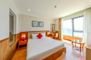 ein Schlafzimmer mit einem großen Bett und einem großen Fenster in der Unterkunft Serene Beach Danang Hotel in Đà Nẵng