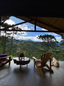 a room with chairs and a dog laying on the floor at Sitio Shekinah in Visconde De Maua