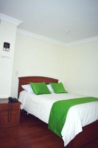 a bedroom with two beds with green and white sheets at Hotel Sello Dorado in Pasto