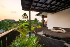 a patio with a table and chairs on a balcony at The Residence Seminyak in Seminyak