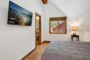 a bedroom with a bed and a tv on the wall at Village Chic Chalet #2113 by Big Bear Vacations in Big Bear Lake