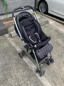 a black stroller sitting in a parking lot at Tokyo Aoto House in Tokyo