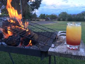 a drink sitting on a table next to a grill at Roode Bloem Farm House in Graaff-Reinet