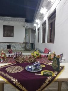a table with a plate of food on top of it at Al-Bashir in Bukhara