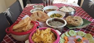 een tafel met kommen eten op een tafel bij NIDHIVANA FARMS & RESORT, bakrebail-salethoor rd, Mangalore in Mangalore