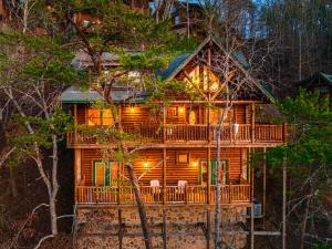 een blokhut in het bos 's nachts bij Fall Sale! NERF War, Theater, HotTub, Pet Friendly, Game Room in Pigeon Forge