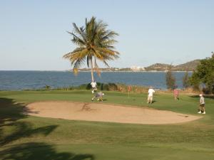 a group of people playing golf on a golf course at Coral Cove Apartments in Bowen