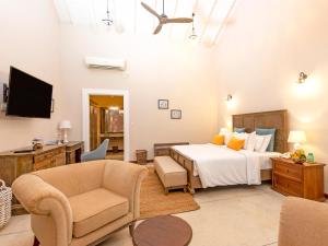 a bedroom with a bed and a chair and a tv at Heritage Boutique in Kandy