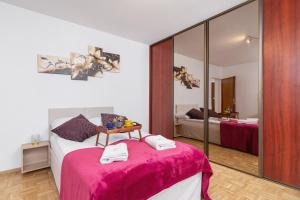 1 dormitorio con 1 cama con manta rosa en Retro Family Apartment Mały Płaszów by Renters, en Cracovia