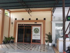 an entrance to a building with a sign on the door at OYO 91162 Homestay Ansyariah Syariah in Palu
