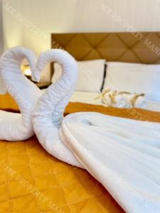 due asciugamani a forma di cigno seduti su un letto di Milos City Center Apt. 32 a Larnaka
