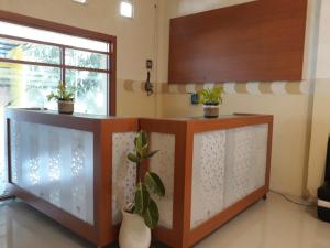 a room with two counters with potted plants and a window at OYO 91162 Homestay Ansyariah Syariah in Palu