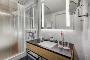 La salle de bains est pourvue d'un lavabo et d'une douche. dans l'établissement IntercityHotel Dortmund, à Dortmund