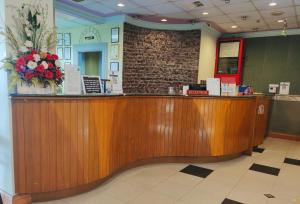 a lobby with a wooden counter with flowers on it at Megah D'aru Hotel in Kota Kinabalu