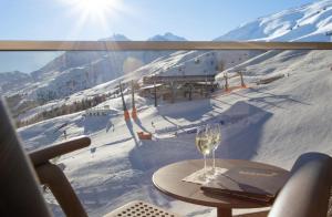 a glass of wine on a table in front of a ski slope at Hotel Edelweiss Hochsölden Superior in Sölden