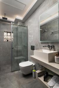 a bathroom with a shower and a toilet and a sink at Archin Boutique suites in Chania +52 photos