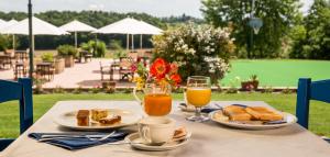 een tafel met twee borden eten en twee glazen sinaasappelsap bij Agriturismo Colleverde in Terricciola