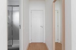 een badkamer met witte muren en een witte deur bij GuestReady - Costa Cabral Guesthouse Room 4 in Porto