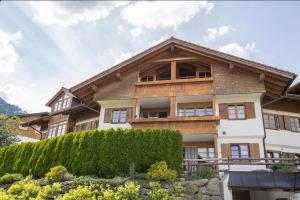 a large wooden house with bushes in front of it at Alpenkönig in Bolsterlang