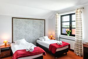 ホイニツェにあるBrowar Gościniec Chojniceのベッド2台と窓が備わるホテルルームです。
