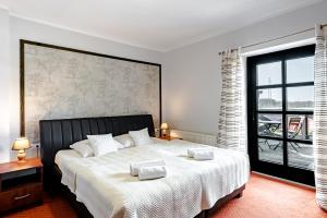 a bedroom with a large bed and a large window at Browar Gościniec Chojnice in Chojnice