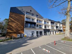 an empty parking lot in front of a building at DWIE SOSNY Baltic 35 in Ustronie Morskie