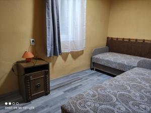 a small bedroom with a bed and a window at Csalogány Apartman in Mezőkövesd