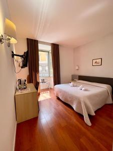 ローマにあるElle Cavour Guest Houseのベッドルーム1室(ベッド1台、テーブル、窓付)