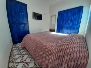 um quarto com armários azuis e uma cama com uma colcha vermelha em Casa Sophia em Ischia