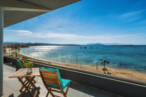 a balcony with a table and chairs and a view of the ocean at Archin Boutique suites in Chania