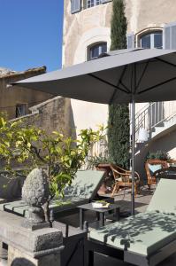 a patio with a table and an umbrella at Le Petit Chateau in Châteauneuf-de-Gadagne