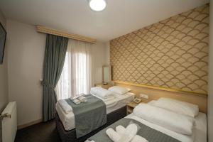 イスタンブールにあるホテル メルタのベッド2台と窓が備わるホテルルームです。