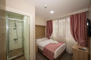 イスタンブールにあるホテル メルタの小さなベッドルーム(ベッド1台、シャワー付)