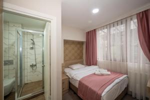 イスタンブールにあるホテル メルタのベッドルーム1室(ベッド1台、シャワー、バスタブ付)