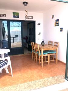 a dining room with a wooden table and chairs at Casa Joe, cosy one bedroom apartment on popular complex with pool in Tías