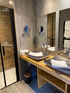 a bathroom with two sinks and a shower at Hôtel Restaurant & Spa Les Autanes in Ancelle