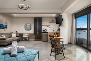 a living room and kitchen with a couch and a table at Archin Boutique suites in Chania